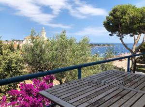 a wooden picnic table on a balcony with flowers at Apartamento con vistas al mar in Cadaqués +26 photos