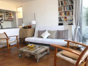 a living room with a white couch and chairs at Apartamento con vistas al mar in Cadaqués