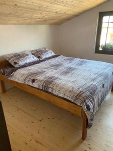 duże łóżko w sypialni z drewnianym sufitem w obiekcie Guest house Tivko Katce Gostivar w mieście Gostiwar