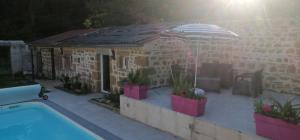 a small house with a pool and an umbrella at La salamandre in Vic-le-Comte