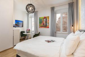 1 dormitorio con cama blanca y mesa en GAMA Dubrovnik 1, en Dubrovnik