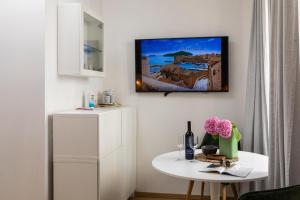 sala de estar con mesa y TV en la pared en GAMA Dubrovnik 1, en Dubrovnik