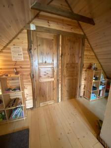 um quarto no sótão num chalé com uma porta em Laane Talu Sauna House em Uhtjärve