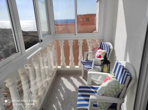 een balkon met 2 stoelen en 2 ramen bij Casa Mary in Granadilla de Abona