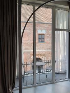 widok na patio ze stołem i krzesłami przez okno w obiekcie Bōheme House w Kownie