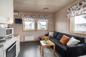 a living room with a black couch in a kitchen at First Camp Björknäs-Boden in Boden
