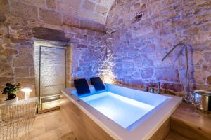 een badkamer met een groot bad in een stenen muur bij Tre Archi Suite & Relais in Polignano a Mare