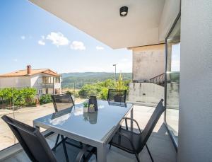 a table and chairs on a balcony with a view at Villa Apartments Lela in Rabac