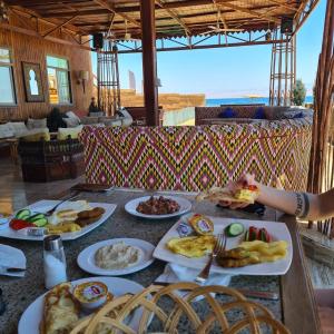 una mesa con platos de comida encima en Ciao Hotel, en Nuweiba