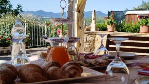 una mesa con comida y vasos de zumo y bollería en Casa delle Noci b&b en Rosora