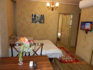 イスタンブールにあるRoyal Suites Sultanahmetのベッド1台、花瓶付きのテーブルが備わる客室です。