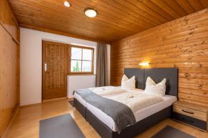 a bedroom with a large bed in a wooden wall at Ferienhaus Anna in Zell am Ziller