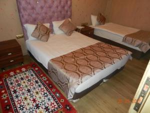 a hotel room with two beds and a rug at Royal Suites Sultanahmet in Istanbul