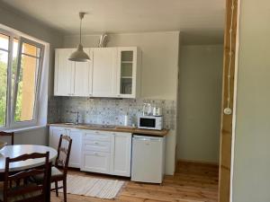 a kitchen with white cabinets and a table and a microwave at Lahe koht in Haapsalu +7 photos