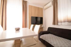 a living room with a white table and a couch at Apartmani Olivia in Bibinje