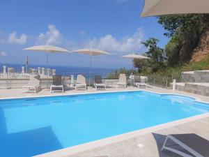 a swimming pool with chairs and umbrellas at Appartamenti Borgo Panoramico N 9 in Tropea