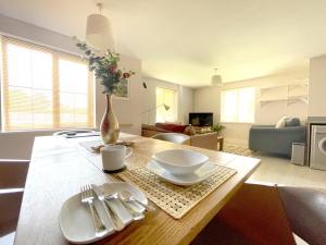 een woonkamer met een tafel met een vaas met bloemen bij Home Crowd Luxury Apartments - Grangefield House in Cantley