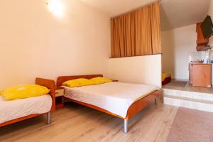 a room with two beds with yellow pillows at Apartments Aurora in Neum