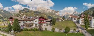 uma aldeia nas montanhas com montanhas ao fundo em Hotel Chalet Dlaces em Selva di Val Gardena