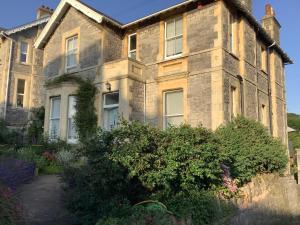 an old brick house with bushes in front of it at Garden apartment in Weston-super-Mare