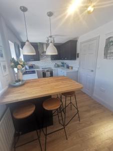 a kitchen with a wooden table and stools at Fell View Cottage in Cockfield