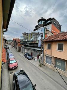 a street with cars parked on the side of the road at Prva Apartment in Novi Pazar