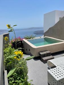 a bath tub sitting on the side of a house at Luxury Villa Blue Dome Santorini in Imerovigli