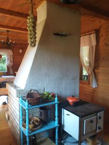 a kitchen with a stove and a table with food at Chabrowa Chatka in Supraśl