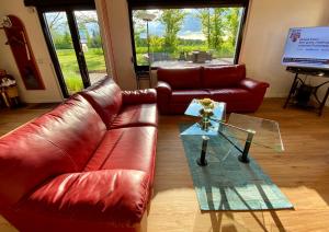 salon ze skórzaną kanapą i szklanym stołem w obiekcie Premium Ferienwohnung Ulf-Dieter Kunstmann w mieście Kremmen