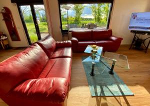 a living room with a leather couch and a glass table at Premium Ferienwohnung Ulf-Dieter Kunstmann in Kremmen