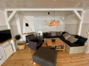 ein Wohnzimmer mit Sofa und Tisch in der Unterkunft "Talludden" by the lake Årydssjön, in Furuby