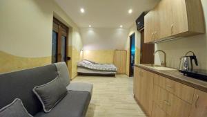 a kitchen with a couch and a bed in a room at Cypla Czar in Polańczyk