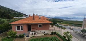een klein huis met een oranje dak op een straat bij Apartmani Matea in Trogir