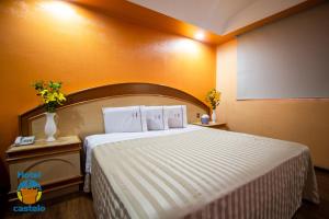 1 dormitorio con 1 cama grande y paredes de color naranja en HOTEL CASTELO, en San Juan del Río