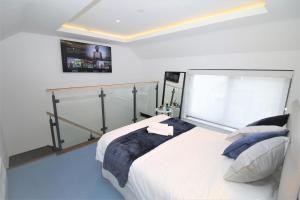 a bedroom with a large white bed with blue pillows at The Coach House - Free Private Parking - by Property Promise in Cardiff