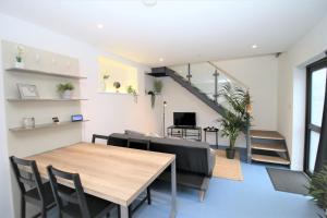 a dining room with a table and chairs and a staircase at The Coach House - Free Private Parking - by Property Promise in Cardiff