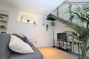 a living room with a couch and a staircase at The Coach House - Free Private Parking - by Property Promise in Cardiff