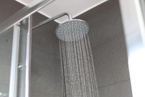 une douche avec pommeau de douche dans une salle de bain dans l'établissement The Coach House - Free Private Parking - by Property Promise, à Cardiff 19 autres photos