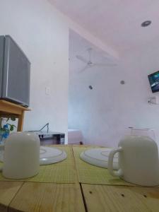 two white coffee mugs sitting on a wooden table at Scondi2 en el depa in Holbox Island