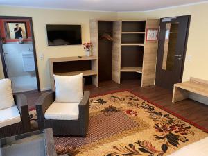 a living room with a couch and chairs and a television at WIRTSHAUS am Niederntor in Blomberg