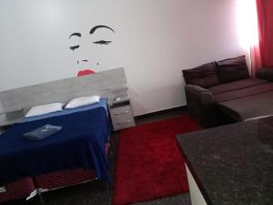 een woonkamer met een bed en een bank bij Hotel Roma in Edéia