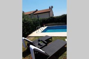 una mesa y sillas junto a una piscina en For Families Only - Casa Nora Novigrad, en Novigrad Istria