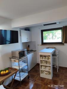a small kitchen with a microwave and a table at SUMMER TIME in Premantura
