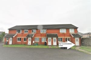 a red brick house with a sign in front of it at Thesiger Court Apartments - Free Private Parking - by Property Promise in Cardiff