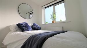 a bedroom with a bed with a mirror on the wall at Thesiger Court Apartments - Free Private Parking - by Property Promise in Cardiff
