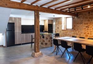 cocina y comedor con mesa y sillas en Casa Rural Pozo Roñañuela en El Royo