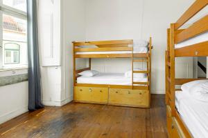 a bunk bed in a room with wooden floors at Rossio Hostel in Lisbon