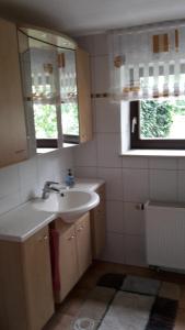 ein Bad mit einem Waschbecken und einem Spiegel in der Unterkunft Oma‘s Häuschen in Schwenningen