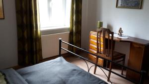 Schlafzimmer mit einem Bett, einem Schreibtisch und einem Fenster in der Unterkunft Oma‘s Häuschen in Schwenningen