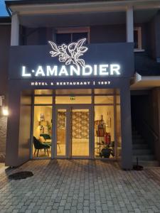 un frente de tienda con una señal que readsiane rancher en Logis Hôtel l'Amandier en Morlaas